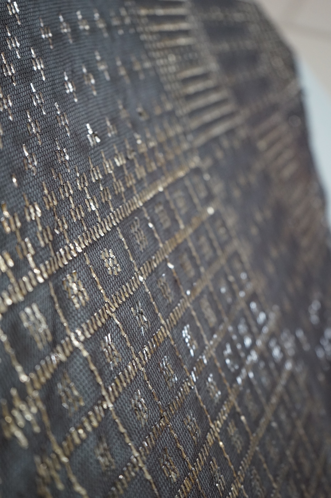 A 1930’s Egyptian decorative metal on black net evening stole. Approximately 218cm long. Condition - the rolled edges are frayed but the colour and design are intact.